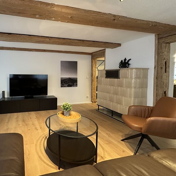 Traditioneller Kachelofen im Wohnzimmer des Ferienhauses in Balgheim