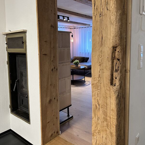 Blick vom Flur in das Wohnzimmer mit Kachelofen im Ferienhaus 1850 in Balgheim